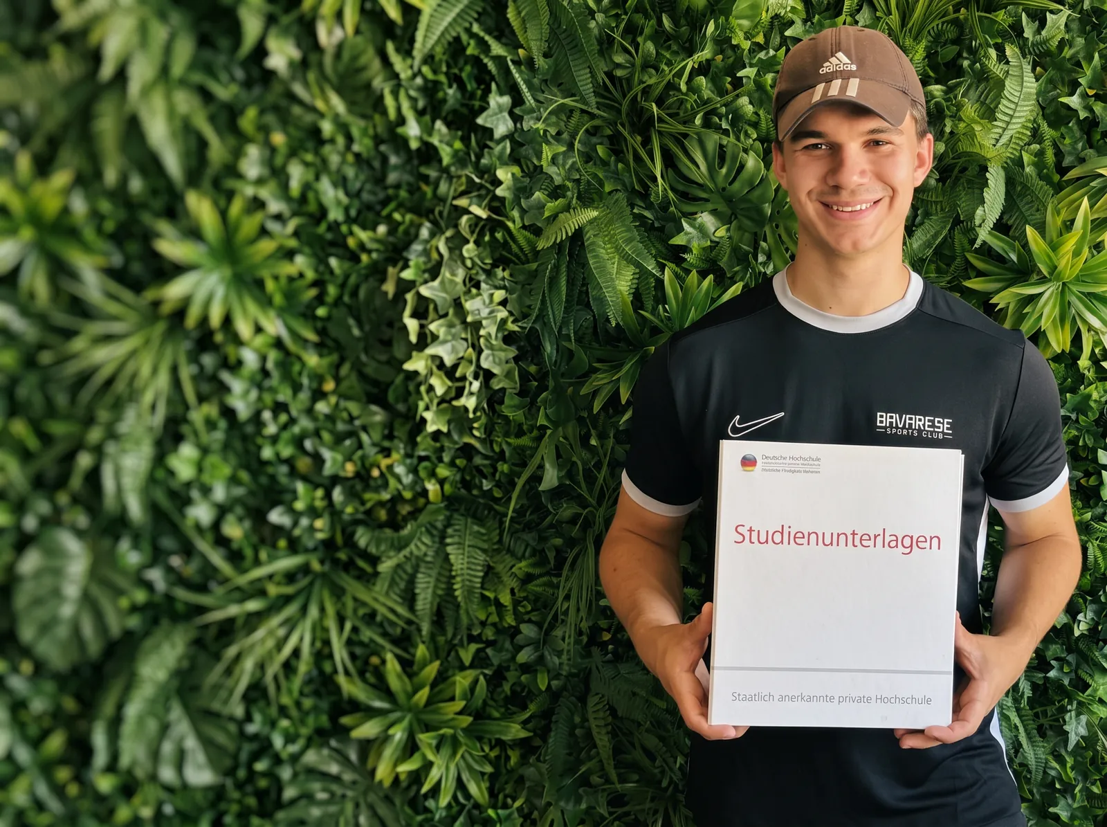 Kevin, dualer Student im Bavarese, mit seinen Studienunterlagen